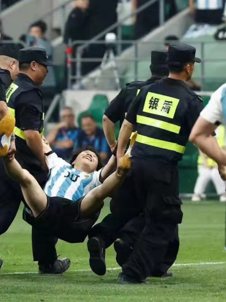 A fan is lift off the pitch during the Argentina/Australia match in Beijing.